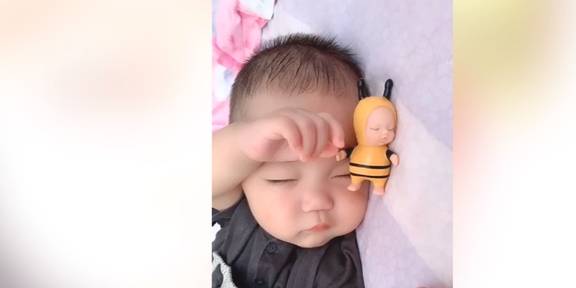 苹果版激萌怎么拼图:宝宝这也太萌了吧，睡在床上的样子，和旁边的娃娃很像啊！